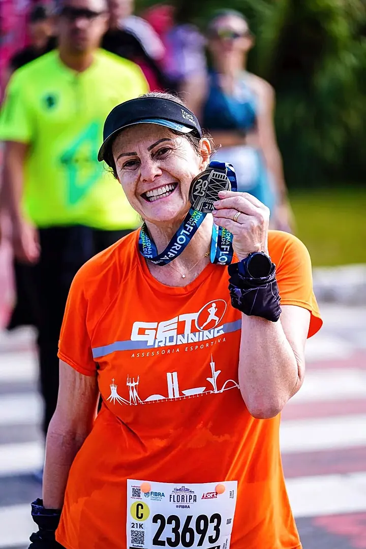 Maria de Fátima sorrindo com a medalha de uma prova